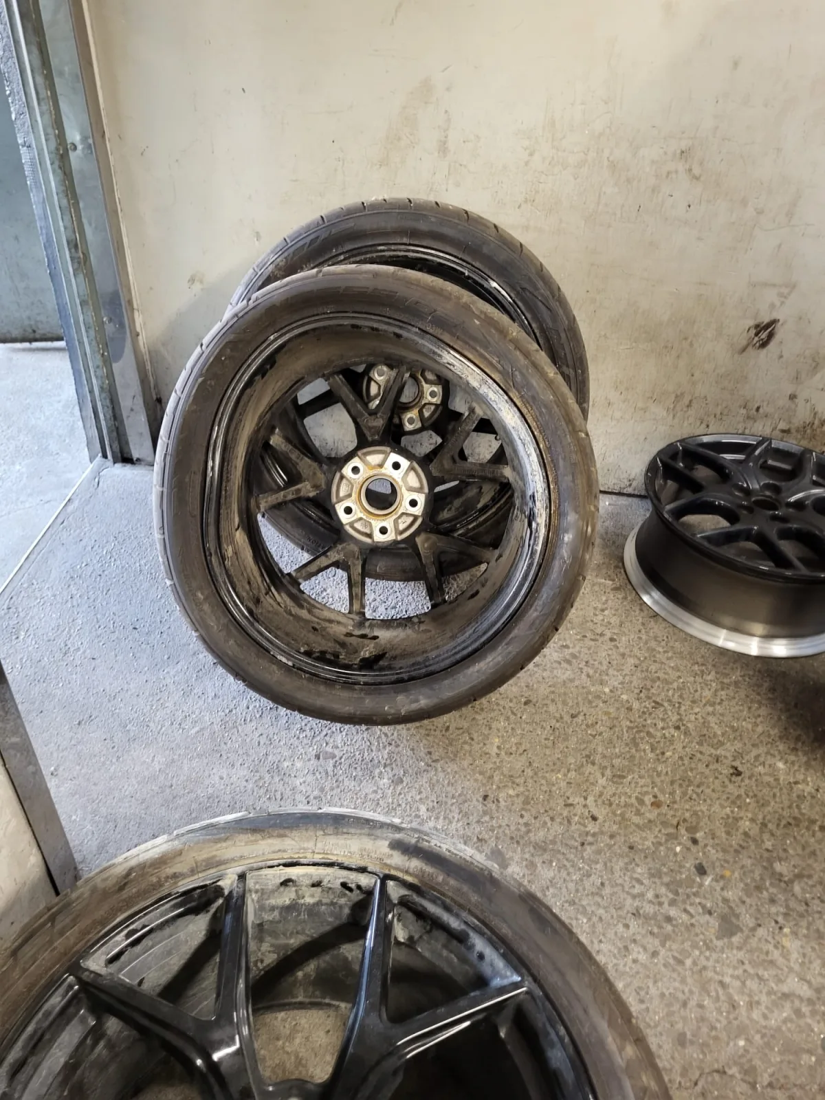 Uszkodzone czarne felgi aluminiowe przygotowane do prostowania i naprawy w KTJ Rzeszów